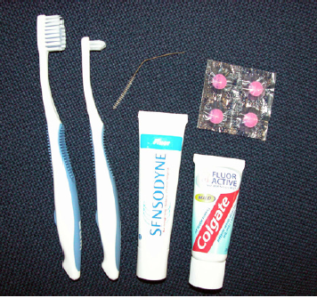  forskellige typer tandbørster, tandpasta og røde farvetabletter