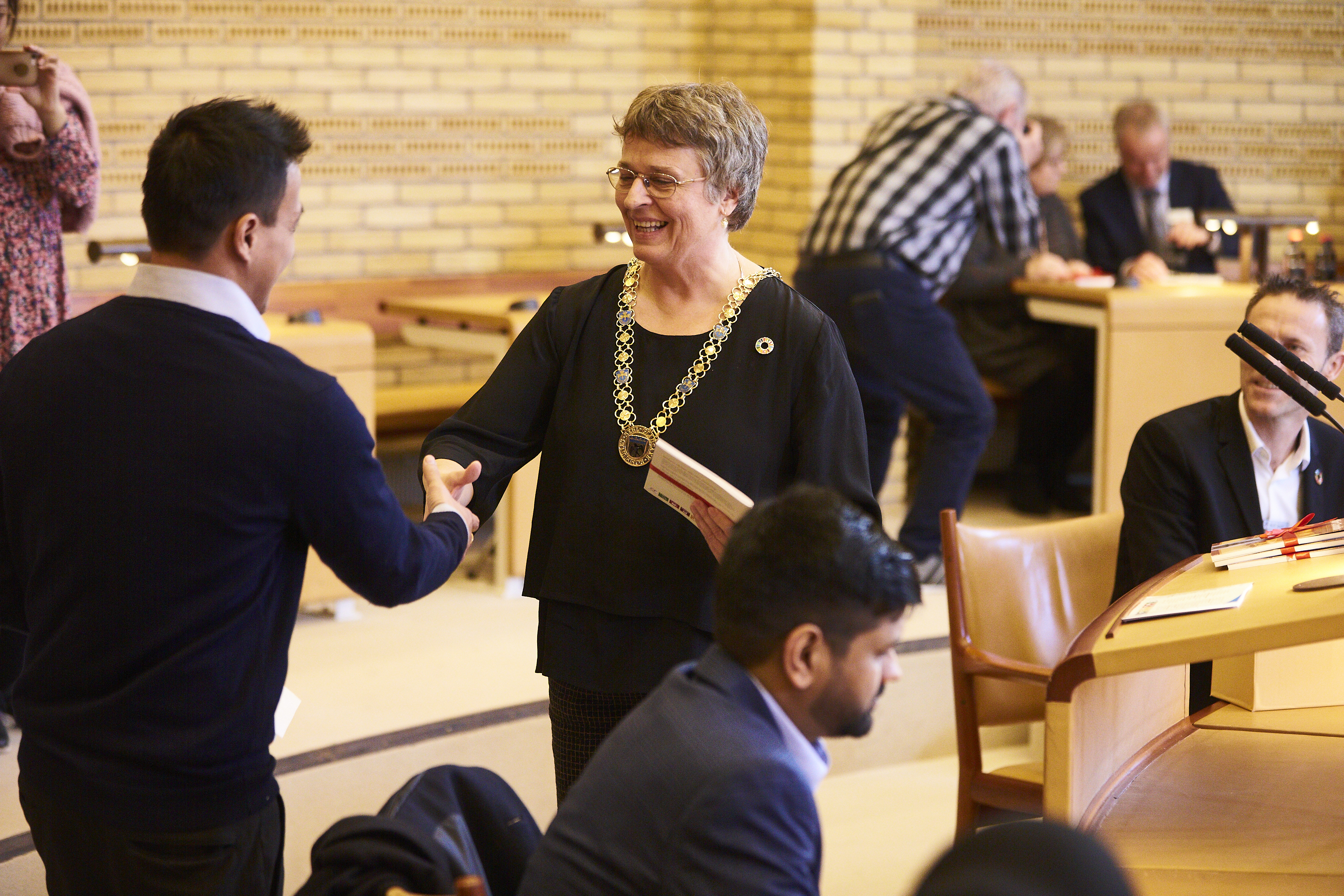 Trine Græse udveksler håndtryk med en ny dansk statsborger